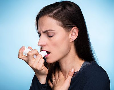 woman with asthma using an inhaler