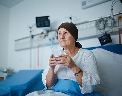 woman with cancer in a hospital bed